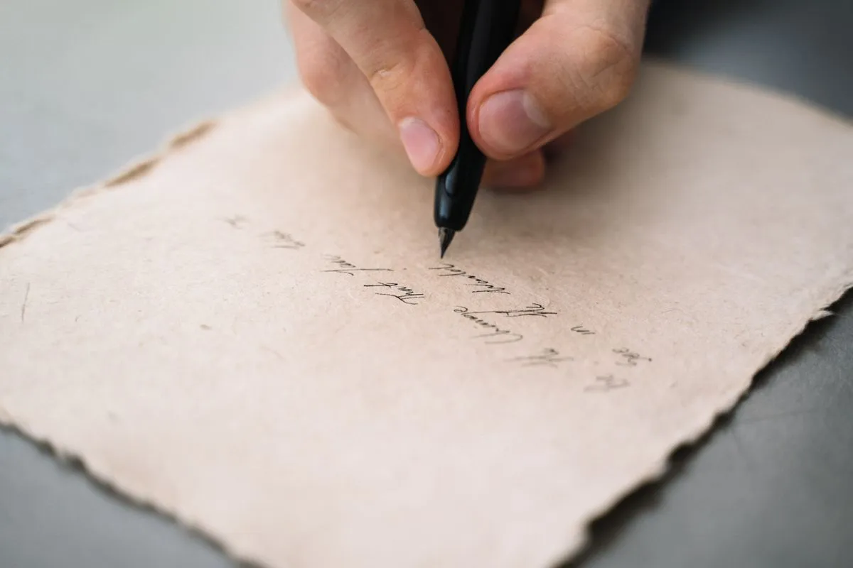 はがきに万年筆で手書きしている手元